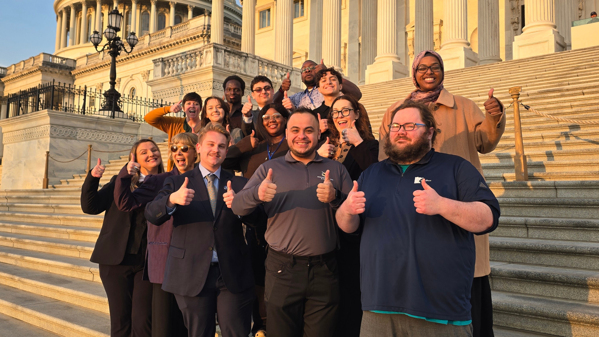 LeadMN students and staff giving thumbs up while bathed in golden morning light in front of the U.S. Capitol Building in D.C.