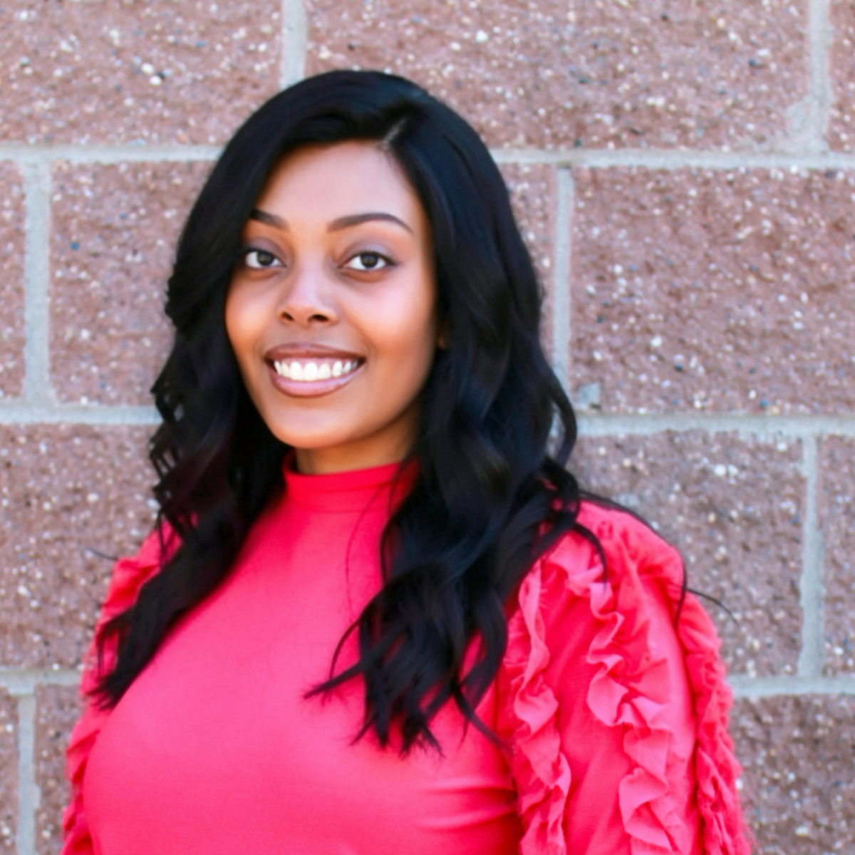 headshot of tamisha williams against copper/red brick